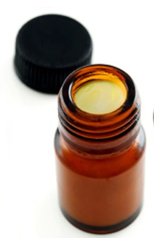 Μικρό καφέ μπουκάλι με ανοιχτό καπάκι.